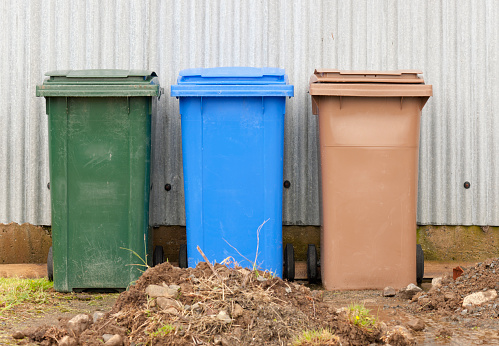 Three plastic 'wheelie bins' for general household waste, recycling and compost.