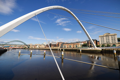 Wide angle view of the River Tyne, with the Gateshead millennium Bridge in the foreground, and the Tyne Bridge along with the city's other bridges in the background.