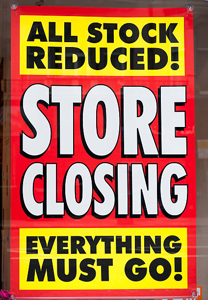 Store Closing Window Display Sign A sign in the window display of a closing shop, advertising clearance prices. closing down sale stock pictures, royalty-free photos & images