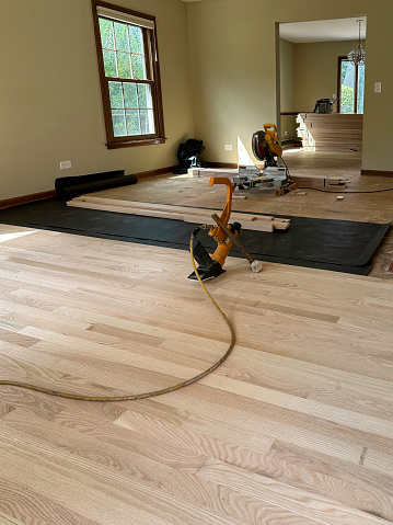 New hardwood floor being installed in a living room