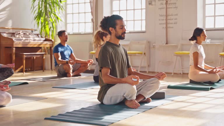 Sporty Middle Eastern Man Doing Yoga With Group
