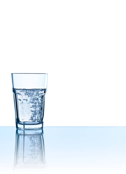 istock Single glass of sparkling water in blue, isolated on white 166025434