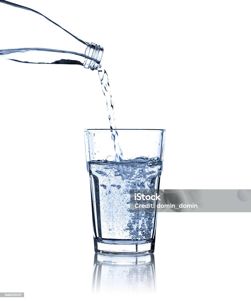 Pouring water from bottle into glass, studio shot, isolated Clear, healthy mineral water pouring water from a bottle into a glass. Studio shot, isolated on white. Water Stock Photo