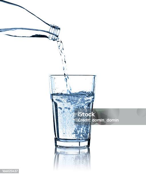 Pouring Water From Bottle Into Glass Studio Shot Isolated Stock Photo - Download Image Now