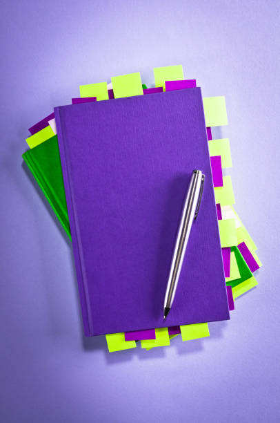 Purple and green notepads with green and purple sticky post-its notes and pen, vignette added.