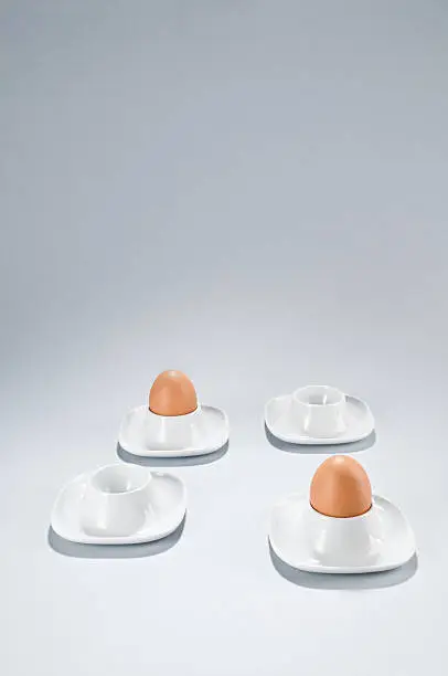 Only two eggs in an eggcups and two more are empty. Copy space, vertical.