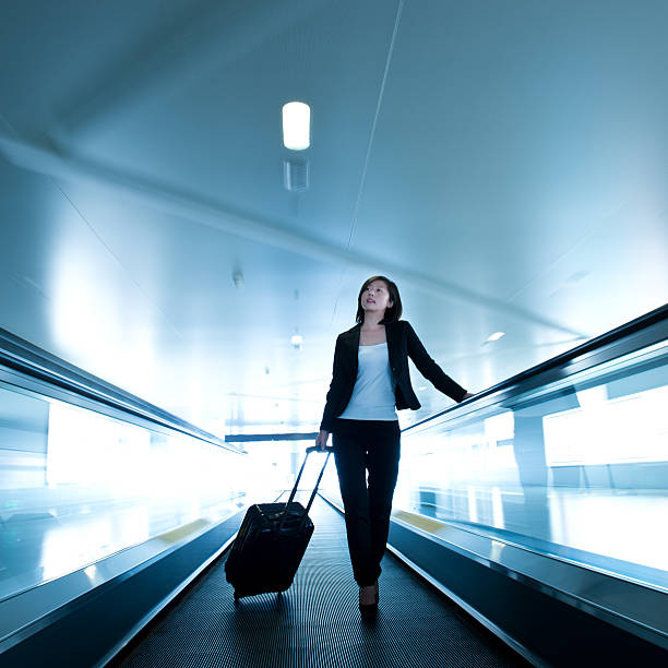 donna d'affari in aeroporto - moving walkway escalator airport walking foto e immagini stock