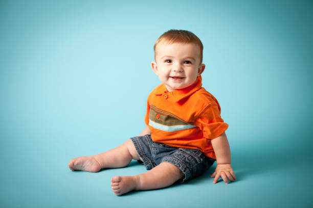 istock Happy Baby Boy Smiling on Teal Background 166025714
