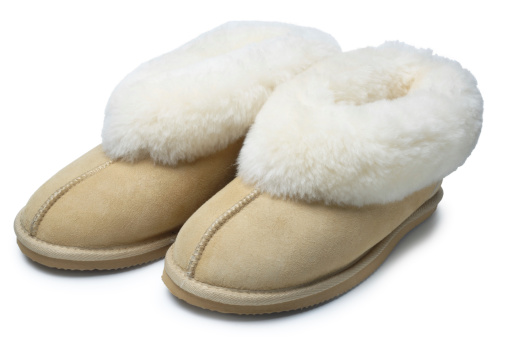 Pair of sheepskin slippers isolated on white.