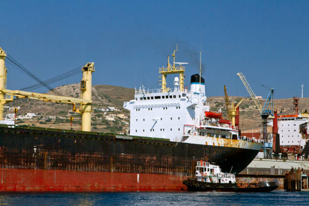 istock Tugboat at work with a ship in a harbor 166029106