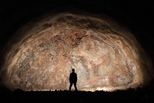 Mine, tunnel front, silhouette of a standing worker