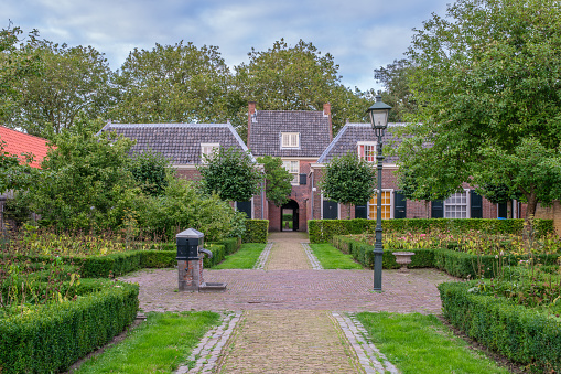 Picturesque residential houses in the old historical almshouse Het Hofje van Pauw, Delft Netherlands, built in 1707. Built for elderly poor people. Medicinal herbs grow in the garden