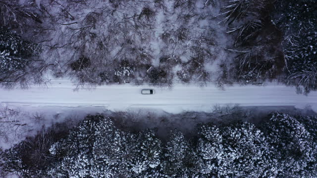 4K Aerial view of Driving car on local road in snowing day