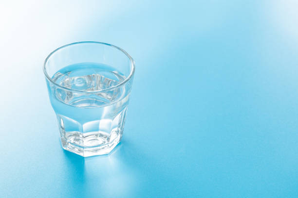 istock Glass of water on blue background. 1660351906
