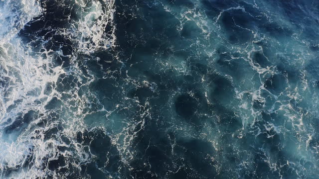 Full frame rough ocean surface texture with swirling whitewash patterns