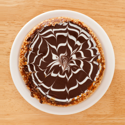 Top view of white dish with ornamented chocolate cake on it