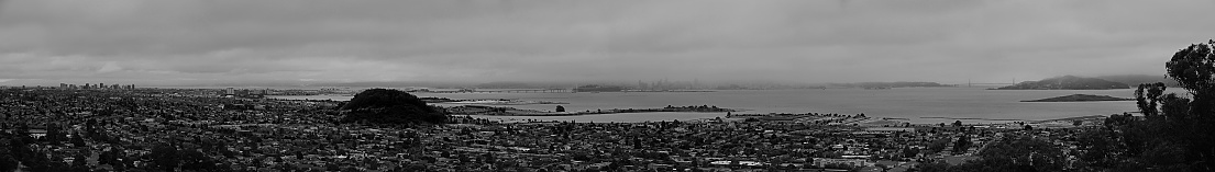 Black and White panramic view of the East Bay from the tp of El Cerrito, mist San Francisco and the Golden Gate Bridge are at the horizon.