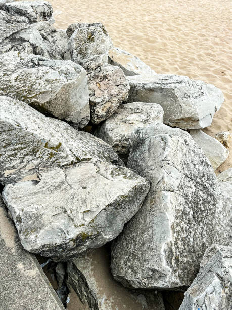 istock Pile of gray colored rocks on sandy beach background 1660444749