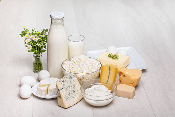 dairy products on wooden background dairy products - milk bottle and glass on wooden background, cottage cheese, eggs, camambert, Parmigiano, Roquefort pasteurization stock pictures, royalty-free photos & images