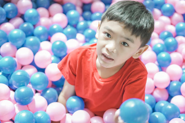 istock boy playing children's playpen pink and blue balls 1660478915