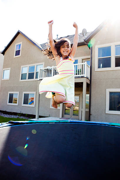 istock Cute Little Girl Jumping on Trampoline 166049370