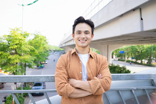 Portrait of young Asian man outside