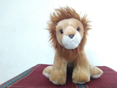 a stuffed lion on a white background is cute and adorable