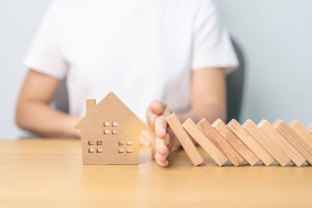 istock hand stop falling wood blocks and protect house model. Crisis, fall Business, Risk, Economic recession, Developer, Real Estate and Property concept 1660515252