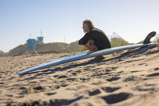 A mature man surfing the waves of Malibu, California USA