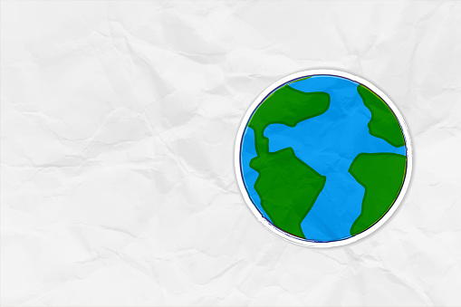A space theme backdrop over white crumpled paper background, with representation of planet earth. There is no people, no text and ample copy space.