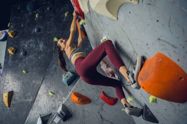 istock A strong female climber climbs an artificial wall with colorful grips and ropes. 1660566764