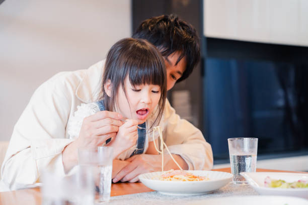 istock A little girl eating dinner with her dad 1660568350