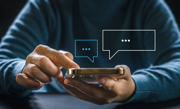 istock Human hand using smartphone typing Live chat chatting and social network concepts, chatting conversation working at home in chat box icons pop up. Social media marketing technology concept 1660570322