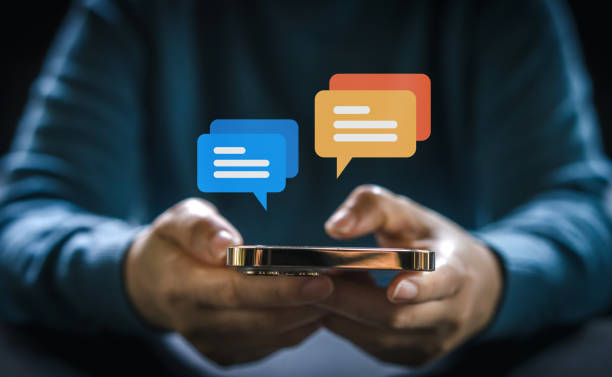 istock Human hand using smartphone typing Live chat chatting and social network concepts, chatting conversation working at home in chat box icons pop up. Social media marketing technology concept 1660570331