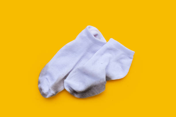 istock Dirty white socks on yellow background. 1660571158