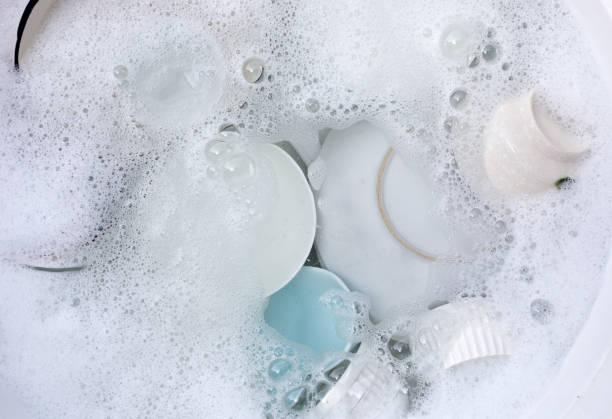 istock Dishes and bowls in water and bubbles of dishwashing liquid. Kitchen work 1660571642
