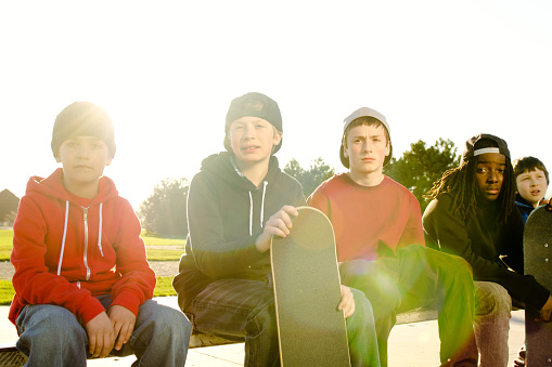 Skateboarders hanging out at a skatepark. Cross processed grainy for dramatic effect. Sunflares and backlit.