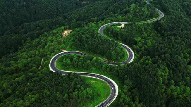 Aerial view of a car driving the curly mountain road