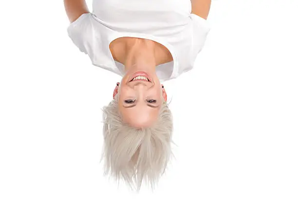 pretty young woman hanging upside down isolated on white