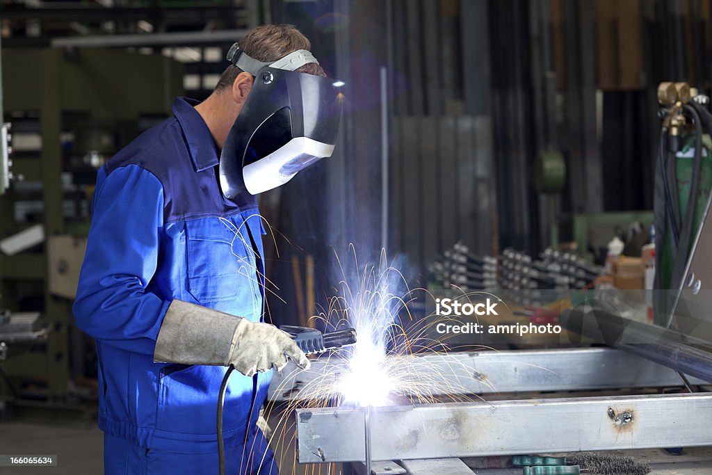 Soldador en el trabajo - Foto de stock de Peto - Prenda de vestir libre de derechos