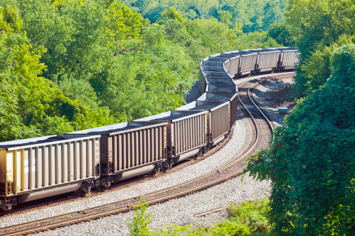 A Coal Train Winding Through A Green Forest In Virginia, USA
