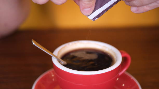 istock Hand is pouring sugar sachet into a cup of coffee. 1660696389