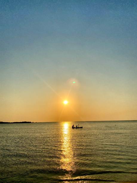 istock Beach sunset with boat silhouette 1660708660