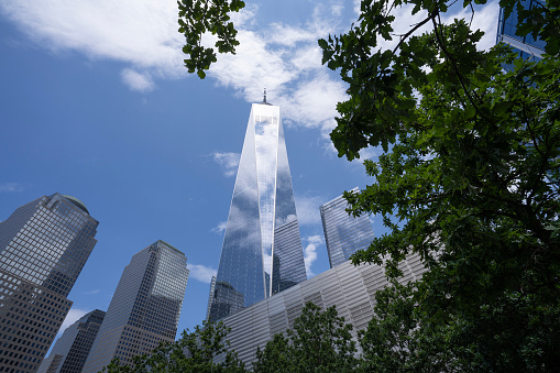 New York, NY, USA - June 4, 2022: One World Trade Center, designed by Skidmore, Owings & Merrill (David M. Childs), with clouds reflected on the facade.