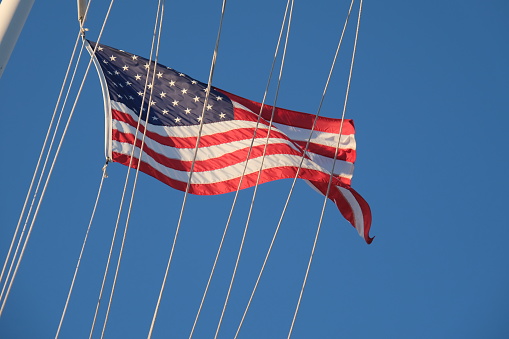 The American flag waving from US Navy ship at sea while underway