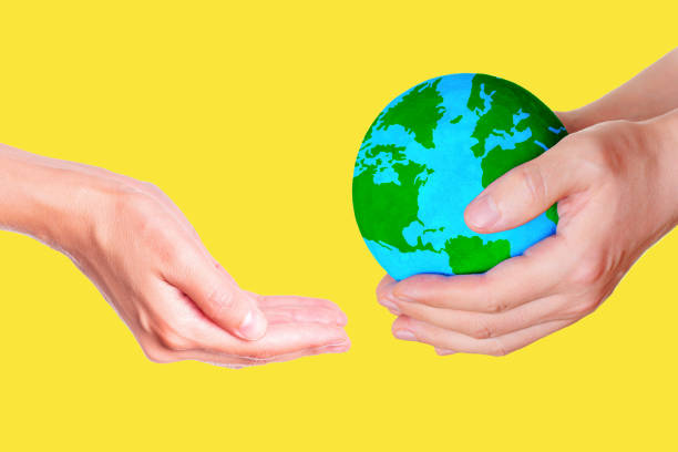 istock Passing the Globe Hand to Hand on Yellow Background 1660758964