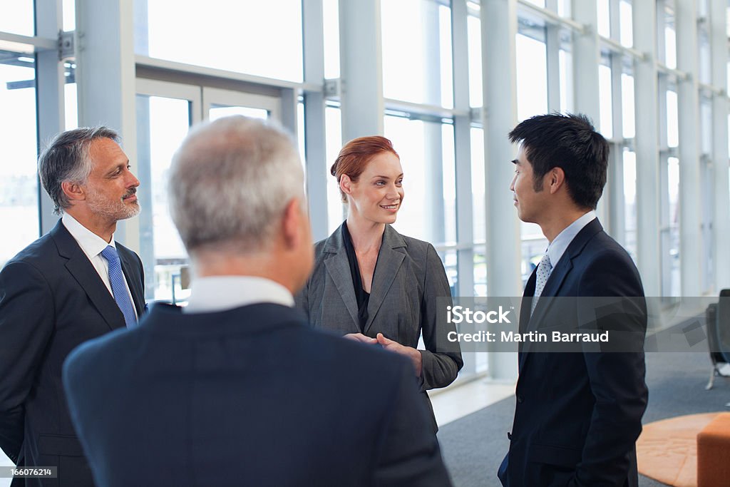 Empresarios hablando en la oficina del lobby - Foto de stock de Estar de pie libre de derechos