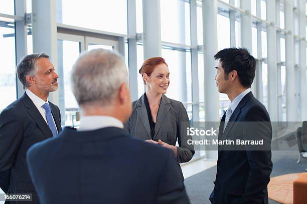 Empresarios Hablando En La Oficina Del Lobby Foto de stock y más banco de imágenes de Estar de pie - Estar de pie, Hablar, Hombres
