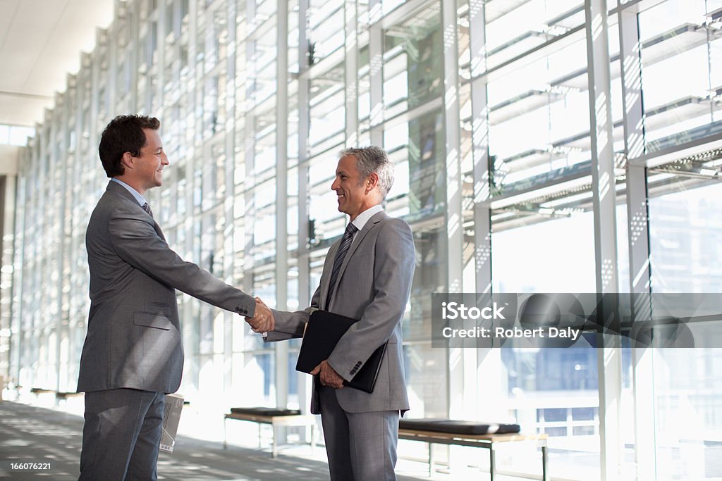 Sorridente Empresário agitando mãos no moderno lobby - Royalty-free Apertar a Mão Foto de stock