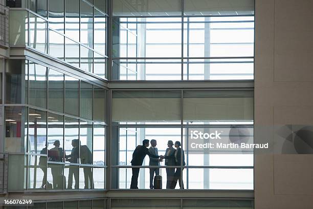 Las Personas De Negocios Hablando En Pasillo De Oficina Moderna Foto de stock y más banco de imágenes de Silueta